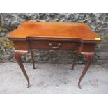 An early 20th century mahogany fold over card table with single inset drawer