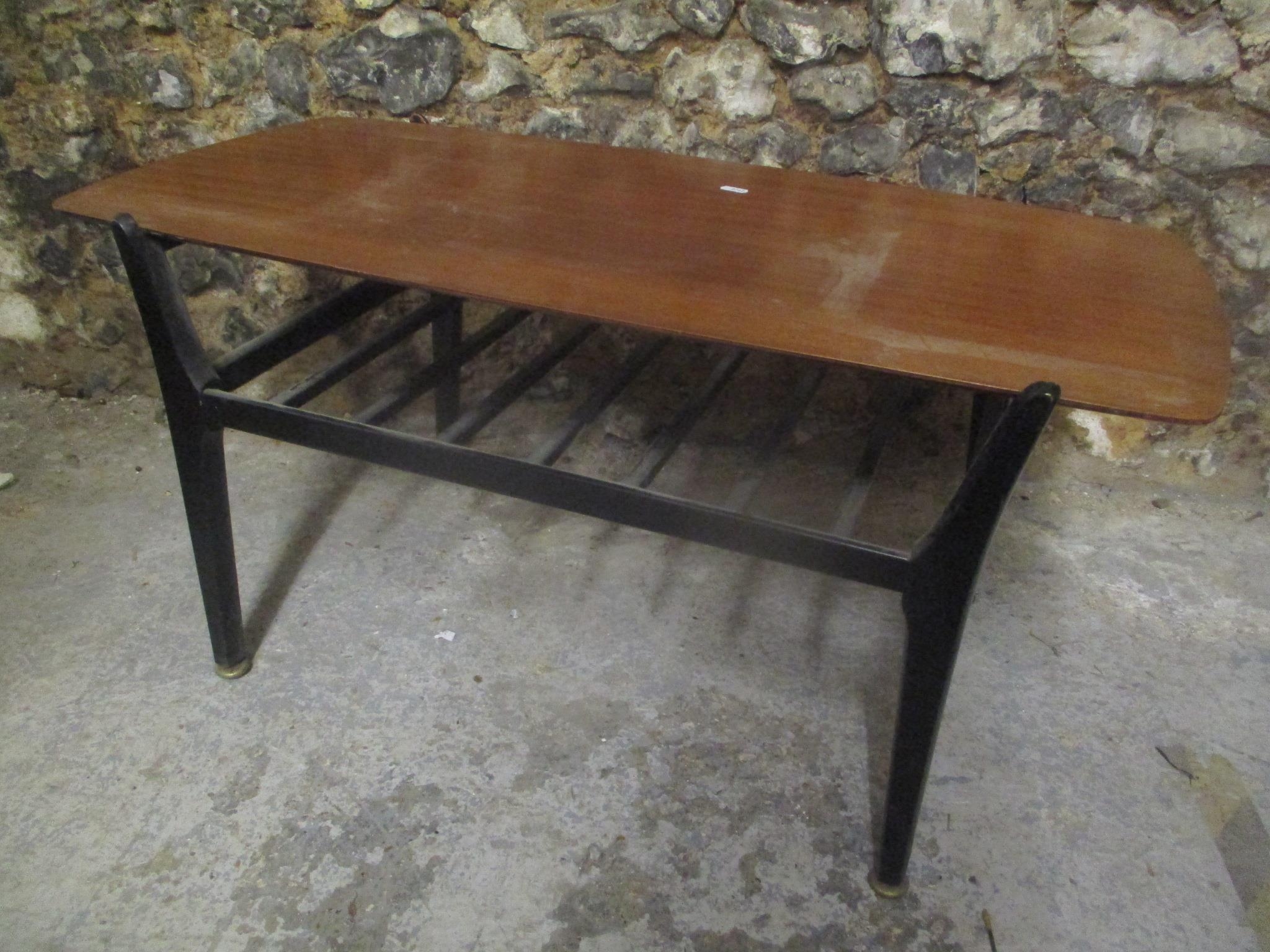 A 1970's retro Nathan teak topped coffee table having ebonised legs and railed magazine tier, 43.5cm