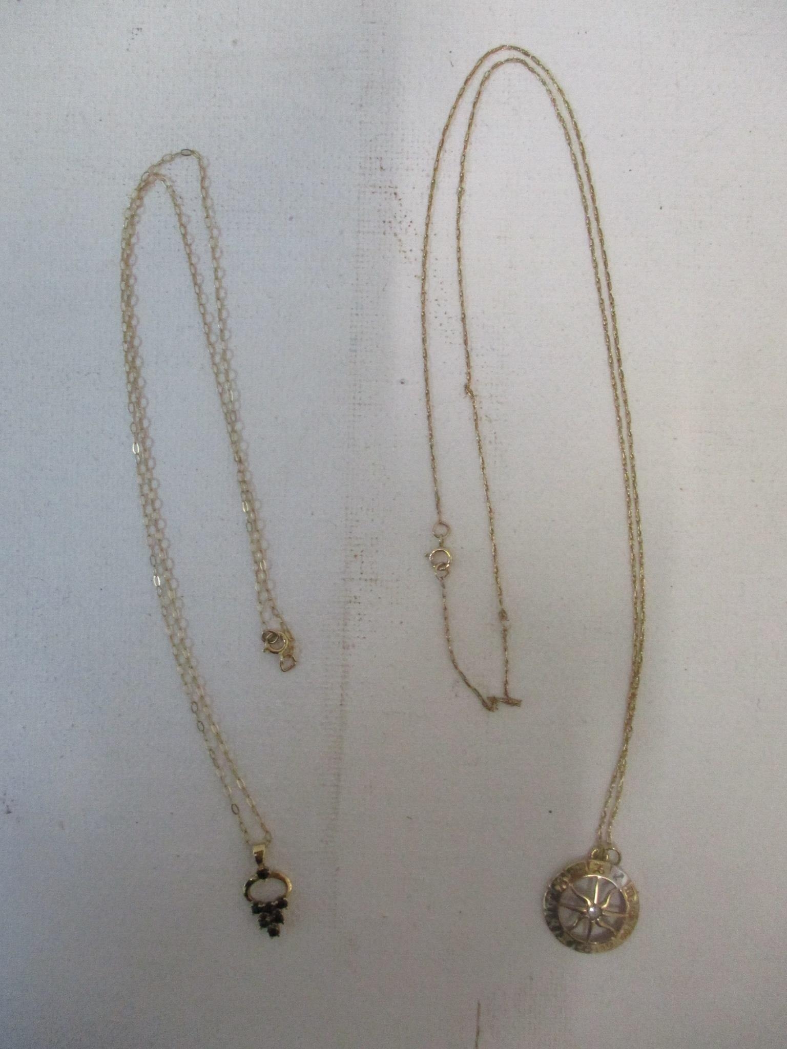 Two gold pendants (unmarked but both test as 9ct), one set with a central aquamarine, the other