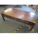 A reproduction mahogany military style coffee table having three inset drawers and on block shaped