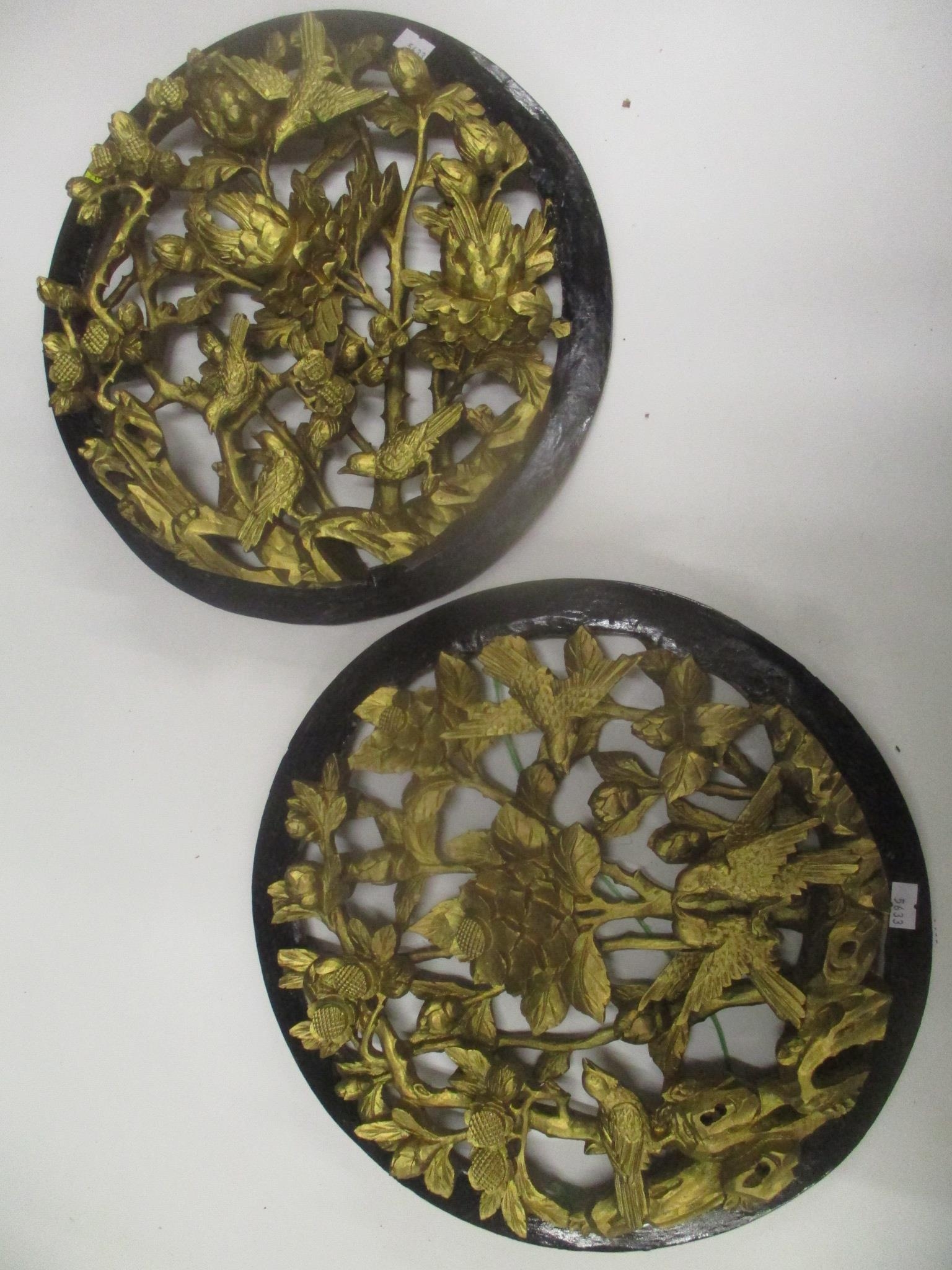 A pair of 20th century Chinese carved gilt and black painted wall plaques 33cm d