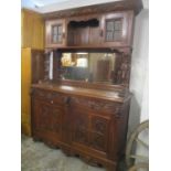 A large 19th century pussy oak carved sideboard having a mirrored back with stepped cornice, two