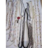 A quantity of pearl, pearlised and mother of pearl necklaces, some having a silver or 14ct gold