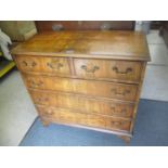 A 20th century walnut chest of two short and three long drawers on bracket feet