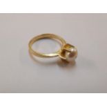 A continental yellow metal ring set with a pearl, tests as 18ct gold, 3g, Location: CABS