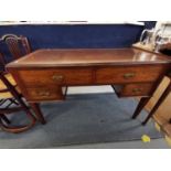 An Edwardian mahogany desk with leather scriber, above four drawers, raised on tapered legs, 75cm h,