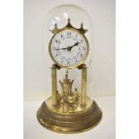 An early 20th century anniversary clock with glass dome, white enamel dial having Arabic numerals