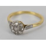 An 18ct gold diamond daisy shaped ring, set with nine diamonds, 3.8g