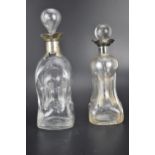 Two late 19th century clear glass glug glug decanters, each with a silver collar, one with four