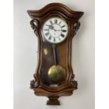 A late 19th century walnut 8 day Vienna regulator wall clock, the circular dial having black Roman