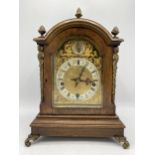 An early 20th century oak mantle clock, the case having gilt metal acorn finial, side mounts and