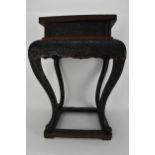 An early 20th century Japanese floral carved cinnabar stand in black, the top carved with a red
