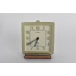 An Art Deco LeCoutre bedside travel/desk alarm clock in a metal case, the dial having Arabic