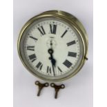 An early/mid 20th century brass cased ships bulkhead clock, the 8 inch dial having Roman numerals