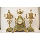 A late 19th century French onyx and gilt metal mantle clock with two matching garnitures. The