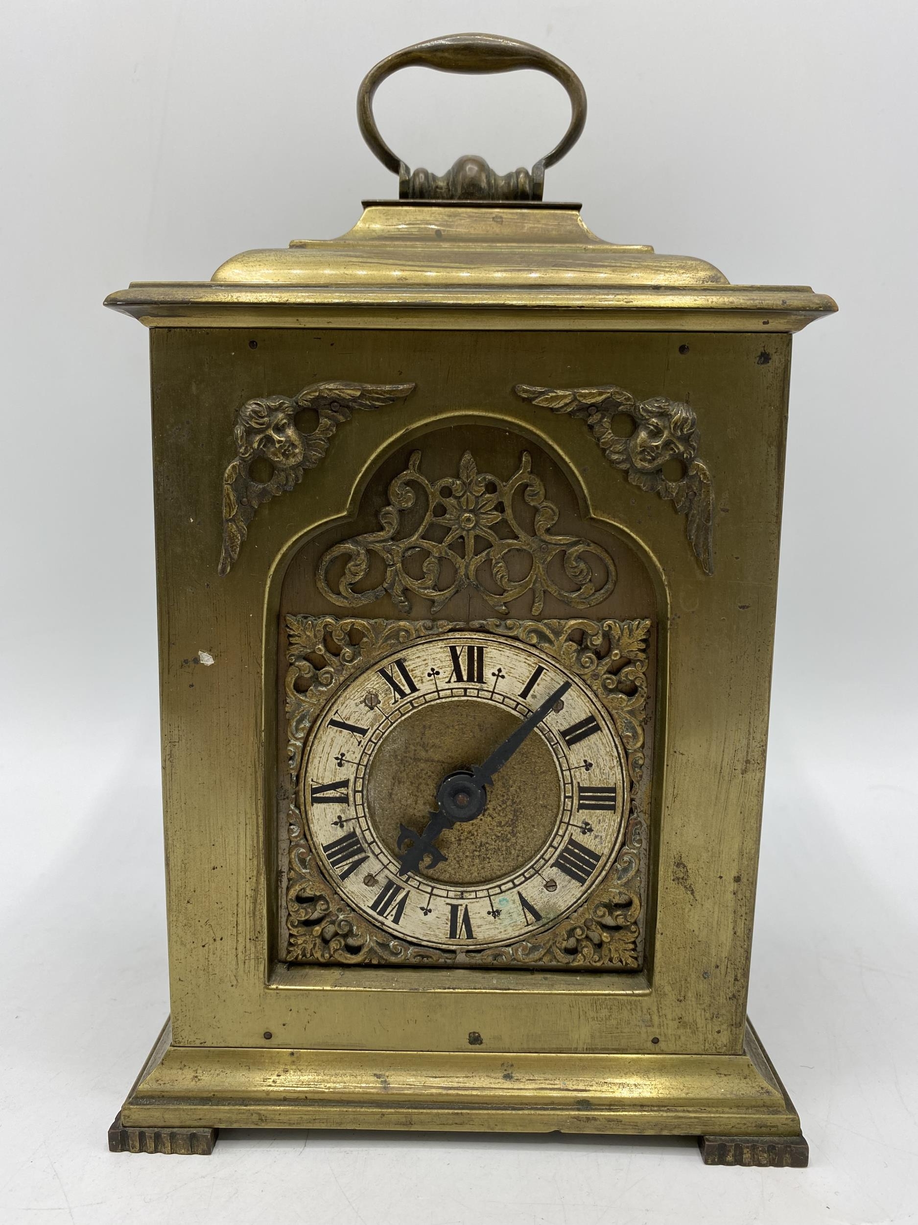 A late 19th century brass cased mantle clock having a silvered dial with Roman numerals with pierced