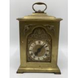 A late 19th century brass cased mantle clock having a silvered dial with Roman numerals with pierced