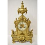 A 19th century French gilt metal mantel clock, the case having an urn shaped finial with floral