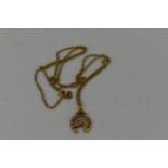 A 9ct gold necklace with a 9ct gold pendant fashioned as a horse shoe and horses head, 7.8g