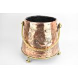 A late 19th/early 20th century Dutch copper and brass coal bucket with a swing handle, cylindrical