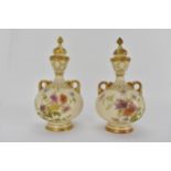 A pair of Royal Worcester blush ivory glazed lidded vases of bulbous form with floral and gilt