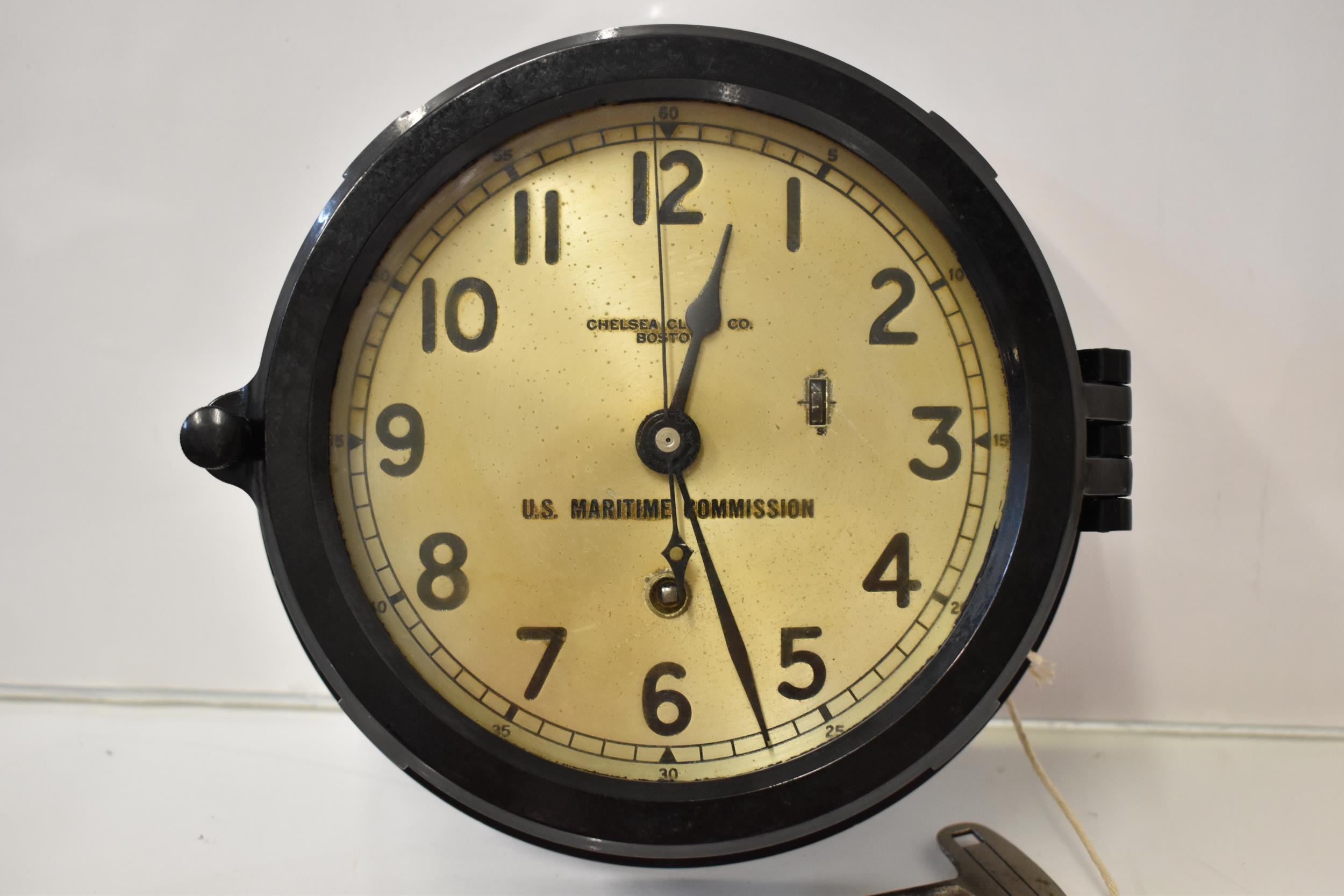 An early/mid 20th century bulkhead ships clock in a black bakelite case, the dial having Arabic