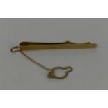 A 9ct gold tie clip by H & H with engine turned decoration and a safety chain, 4.8g