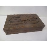 A World War II Indian carved hardwood cigarette box decorated with two mythical creatures and