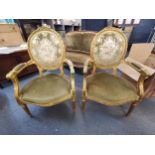 A pair of Louis XVI style gilt wood fauteuils with velour upholstery, raised on reeded tapered