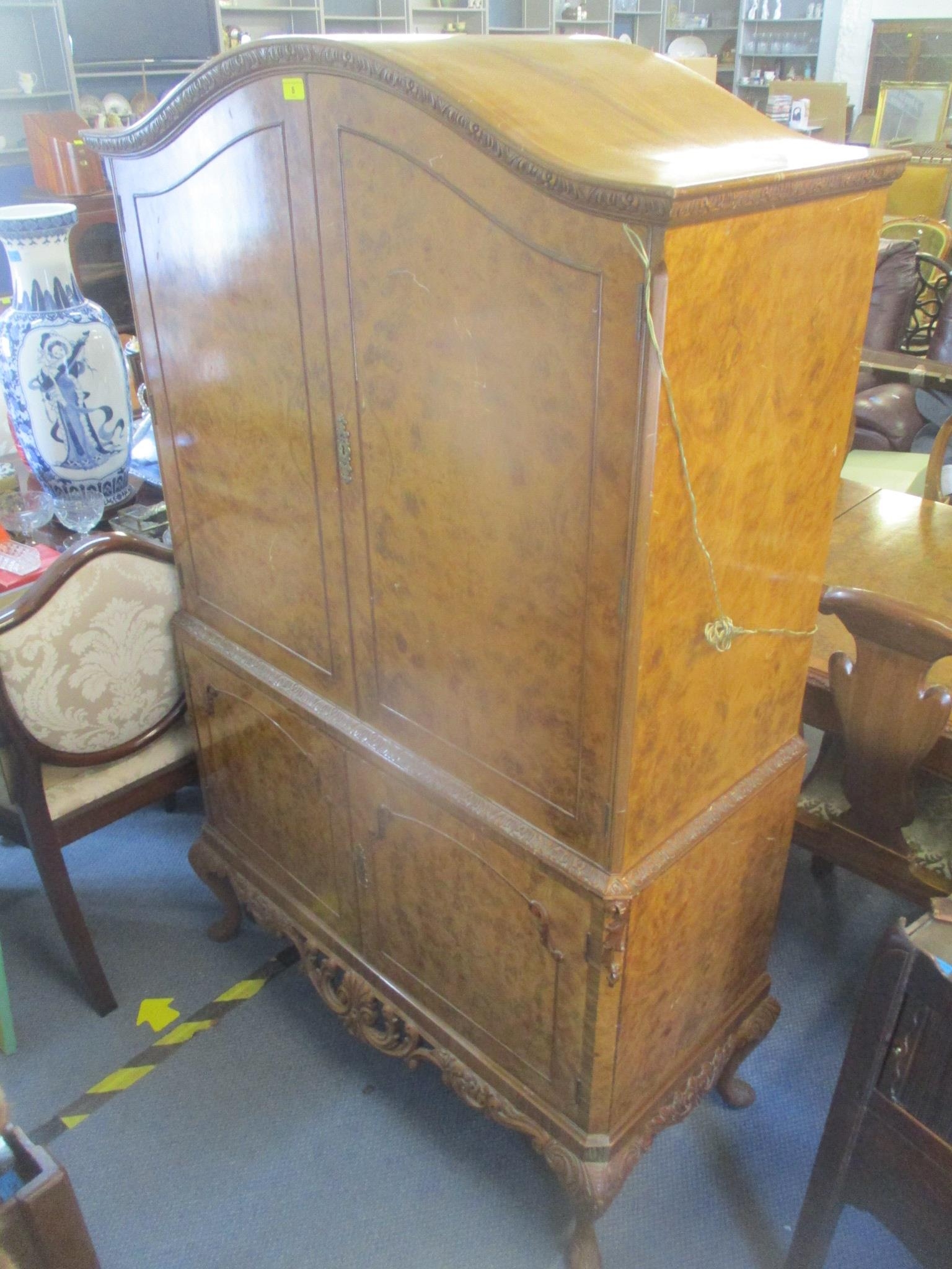 A 1950's walnut cocktail cabinet having four cupboard doors with fitted interior standing on short