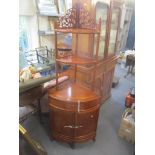 A modern exotic wood Chinese corner unit having three open graduated shelves with bow fronted