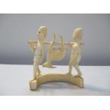 An early 20th century African carved ivory figure group of two men carrying an antelope suspended