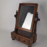 An early 19th century walnut swivel dressing table mirror with two drawers below Location: G