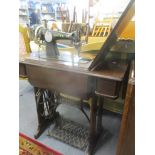 An early 20th century oak and iron Singer treadle sewing table and machine, Serial number EK225243