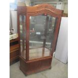 A modern rosewood Chinese display cabinet having a large glazed door above two small cupboard