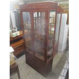 A modern rosewood Chinese display cabinet having twin glazed doors revealing intersectional