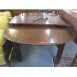 An Edwardian mahogany extending dining table with one extra leaf, having gadrooned edge, pierced