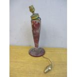 A cameo brown/red opaque glass lamp base decorated with vines, leaves and flowers, on splayed foot