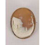 An early 20th century 9ct gold cameo brooch depicting a figure by a barn, 4cm high, unmarked but