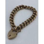 An early 20th century 9ct gold curb link bracelet with heart locket clasp, hallmarked Birmingham