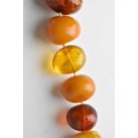 An amber necklace with large graduated beads of varying colours, 50cm long, largest bead 29mm,