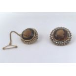 A near pair of citrine and seed pearl inset circular brooches, one stamped 15ct other testing as