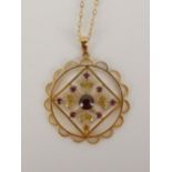 An early 20th century gold pendant set with pink and red stones, one stone missing, marked 9ct, W