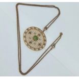 An Edwardian peridot and seed pearl circular pendant, testing as 15ct gold, on a 9ct gold