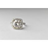 A ring set with a white stone within a band of diamonds, the shank set with diamonds stamped 750,