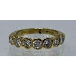 An 18ct gold diamond half eternity ring having seven diamonds in a rub over setting, each approx 3mm