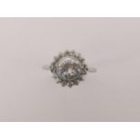 An 18ct white gold ring set with central diamond approximately 1.5ct surrounded by 16 brilliant