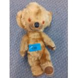 A vintage Merrythought teddy bear with glass bead eyes and a label to the foot, 23cm high.