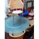 A modern glass circular topped dining table together with four cane back chairs Location: