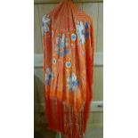 A 1920's red hand-embroidered shawl with long tasselled fringe, depicting images of flowers and